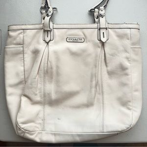 Coach handbag with beige color and a lavender color inside.
